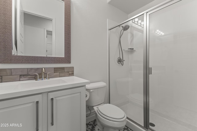 bathroom featuring vanity, decorative backsplash, toilet, and a stall shower