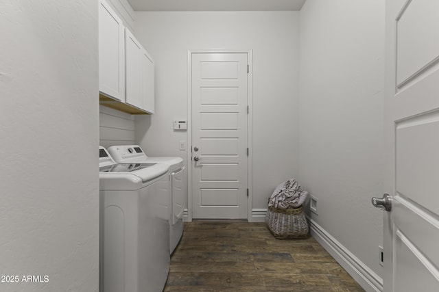 laundry room with dark wood finished floors, washing machine and dryer, cabinet space, and baseboards