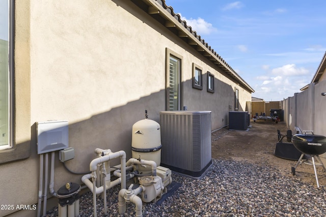 view of home's exterior featuring central air condition unit, a fenced backyard, and stucco siding