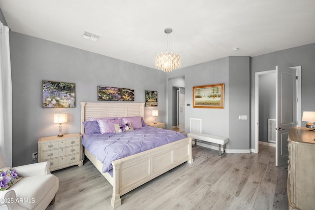 bedroom with a notable chandelier and light hardwood / wood-style flooring