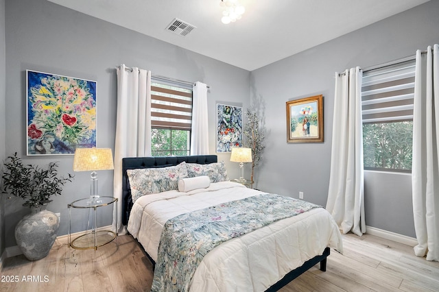 bedroom featuring visible vents, baseboards, and wood finished floors