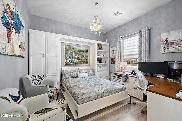 bedroom featuring light wood-type flooring and a notable chandelier