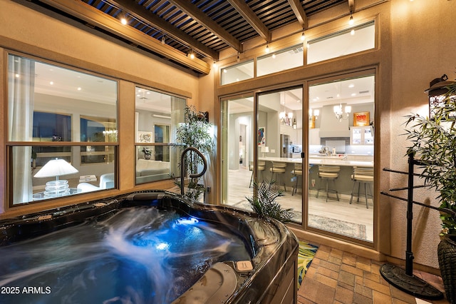 interior space with beam ceiling, a chandelier, and a jacuzzi