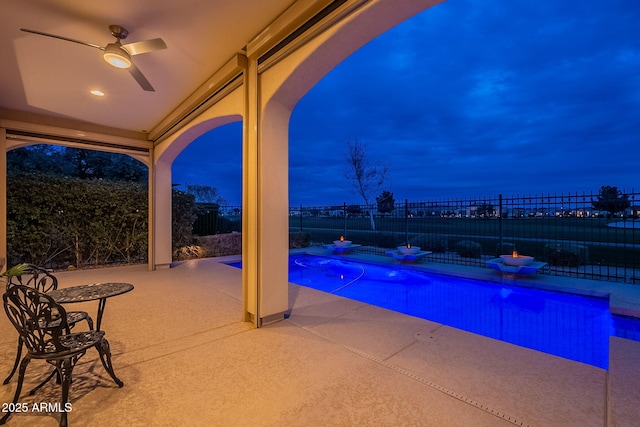 pool at twilight featuring a patio area, a fenced backyard, a fenced in pool, and a ceiling fan