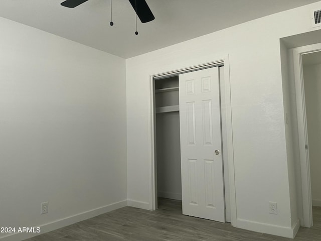 unfurnished bedroom featuring wood-type flooring, a closet, and ceiling fan