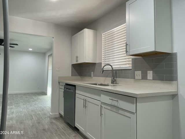 kitchen with dishwasher, white cabinets, light hardwood / wood-style floors, and sink