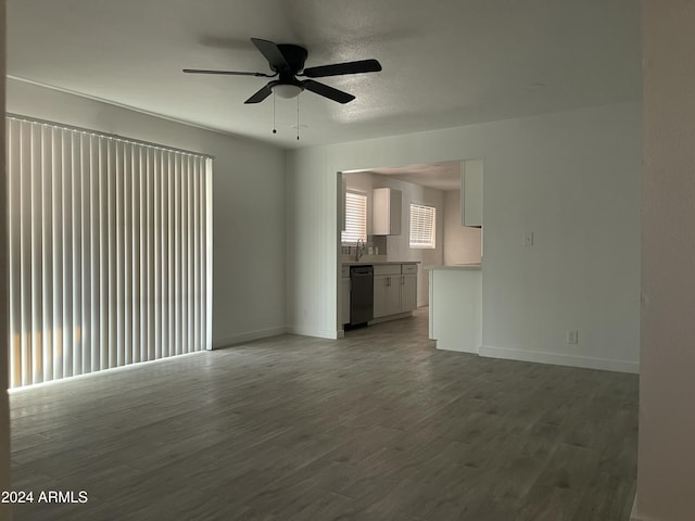 unfurnished living room featuring hardwood / wood-style flooring, ceiling fan, sink, and a textured ceiling