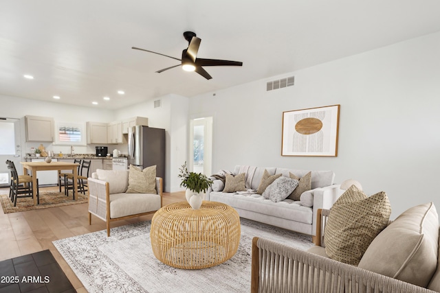 living room featuring light wood-type flooring and ceiling fan