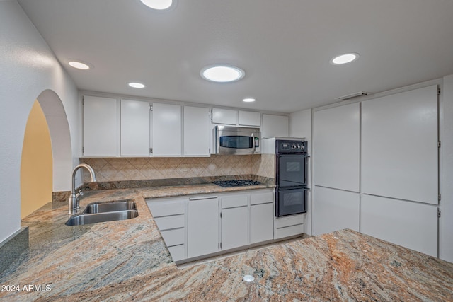 kitchen featuring backsplash, stainless steel appliances, white cabinetry, and sink