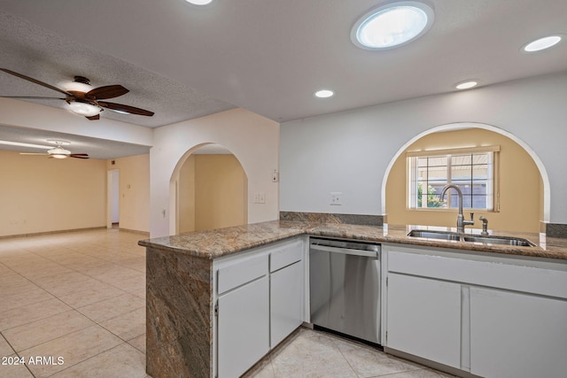 kitchen featuring dishwasher, sink, light tile patterned floors, kitchen peninsula, and white cabinets