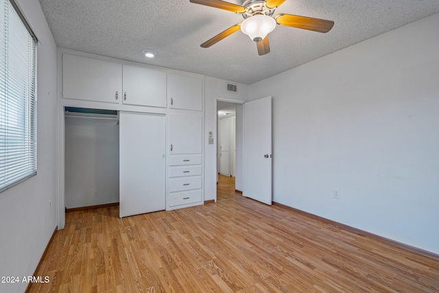 unfurnished bedroom featuring a textured ceiling, light wood-type flooring, a closet, and ceiling fan