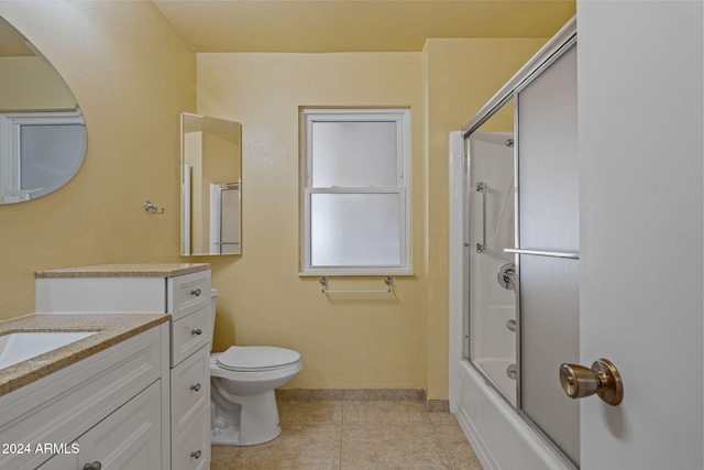 full bathroom featuring tile patterned floors, vanity, toilet, and combined bath / shower with glass door