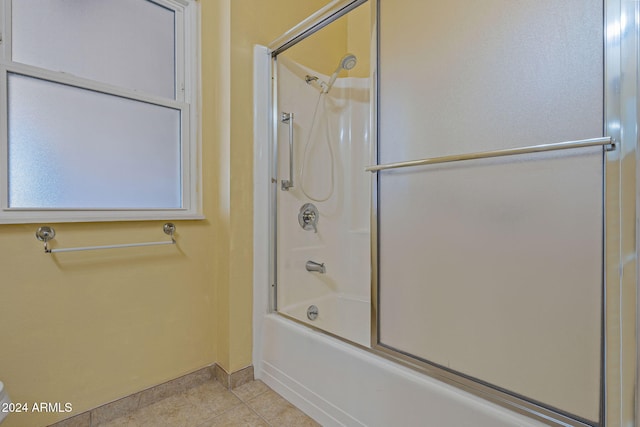 bathroom with tile patterned flooring and bath / shower combo with glass door