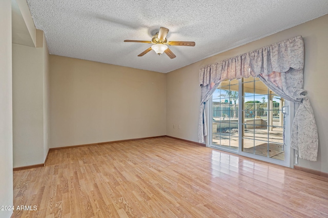 spare room with ceiling fan, light wood-type flooring, and a textured ceiling