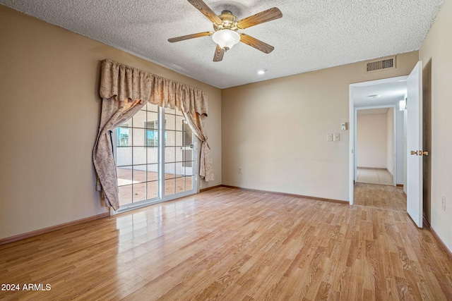 empty room featuring ceiling fan, a textured ceiling, and light hardwood / wood-style flooring