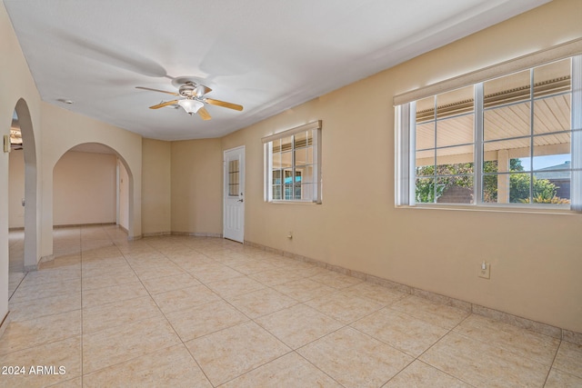 tiled spare room featuring ceiling fan