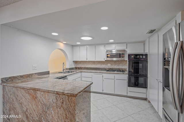 kitchen featuring white cabinetry, sink, stainless steel appliances, kitchen peninsula, and light tile patterned floors