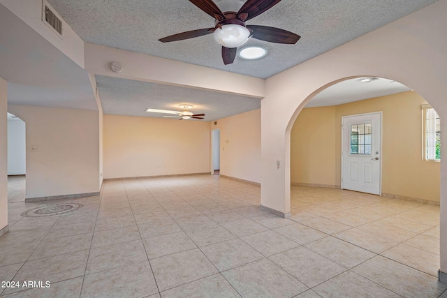 tiled spare room with ceiling fan and a textured ceiling