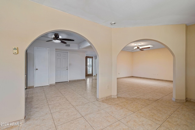 unfurnished room featuring light tile patterned floors, a textured ceiling, and ceiling fan