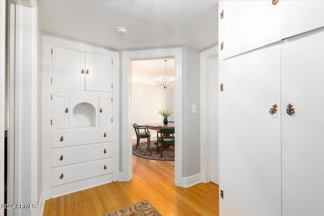 interior space with a notable chandelier and light wood-type flooring