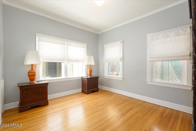 interior space with light wood-type flooring and ornamental molding