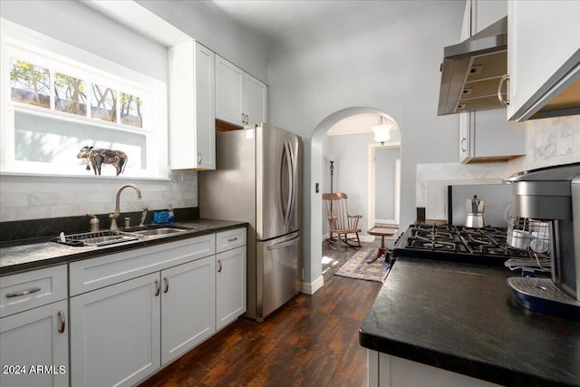 kitchen with dark hardwood / wood-style floors, stainless steel fridge, sink, decorative backsplash, and white cabinetry