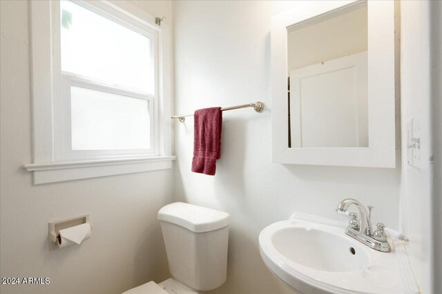 bathroom featuring plenty of natural light, toilet, and sink