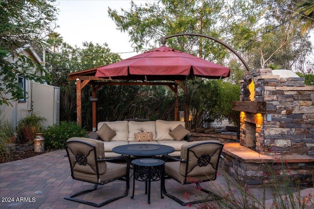 view of patio / terrace featuring a gazebo and an outdoor living space with a fireplace