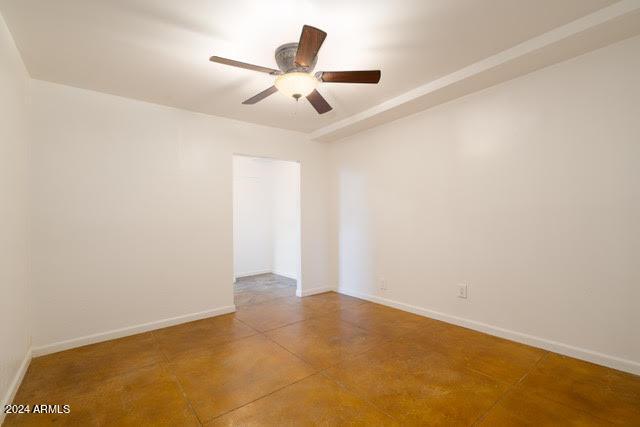 empty room with concrete flooring and ceiling fan