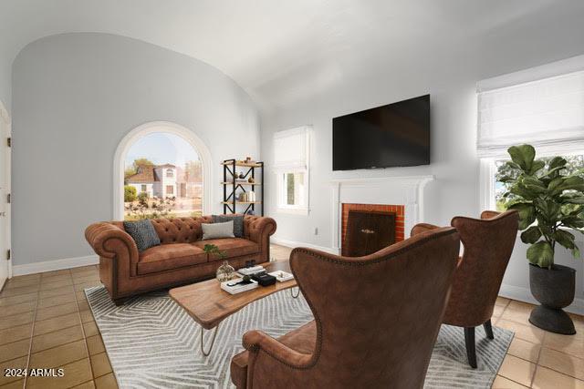 living room featuring lofted ceiling, light tile patterned flooring, and a fireplace