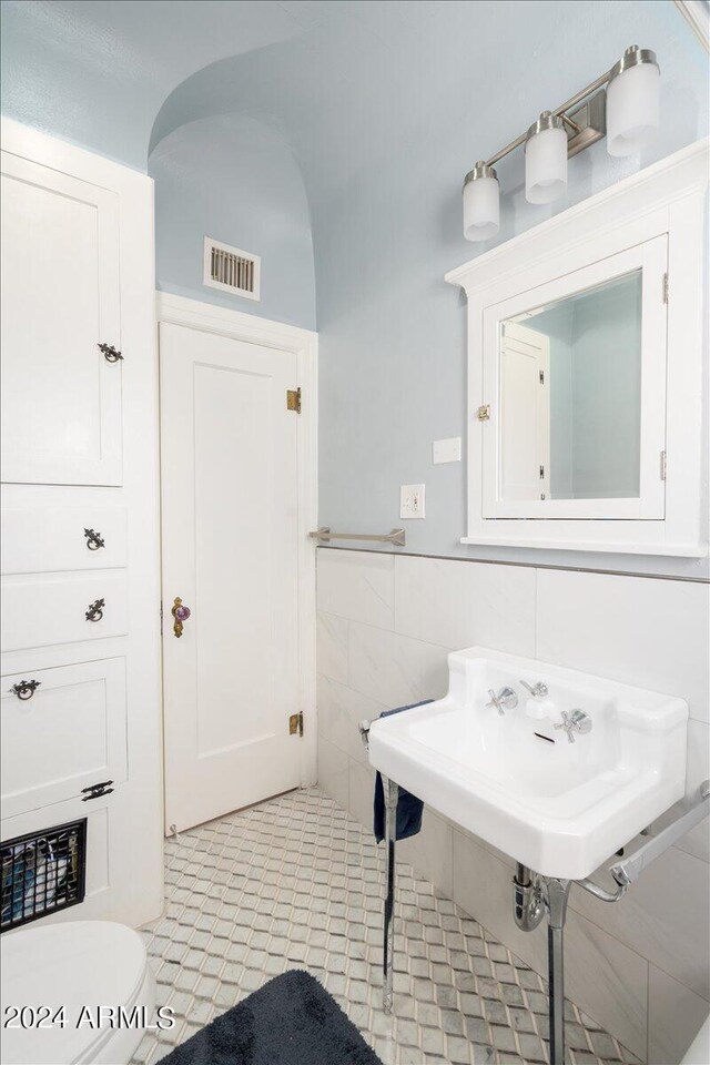 bathroom featuring tile walls, toilet, and tile patterned floors