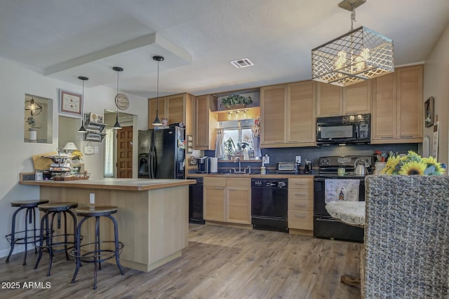 kitchen with a chandelier, visible vents, light wood-style floors, and black appliances