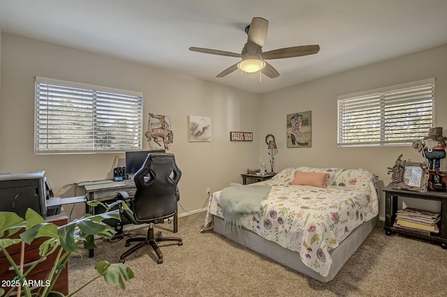 carpeted bedroom with ceiling fan, baseboards, and multiple windows