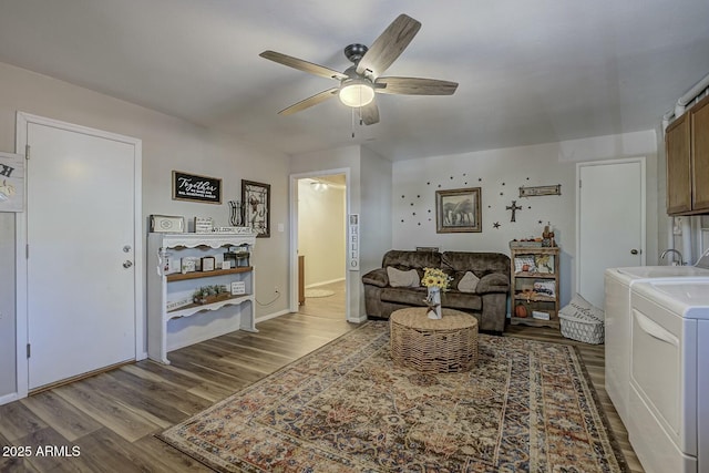 living room with wood finished floors, a ceiling fan, baseboards, and washer and clothes dryer