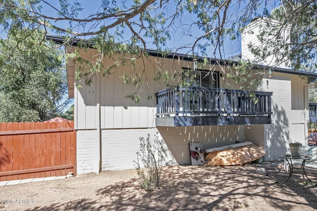 back of house with fence, brick siding, and a patio