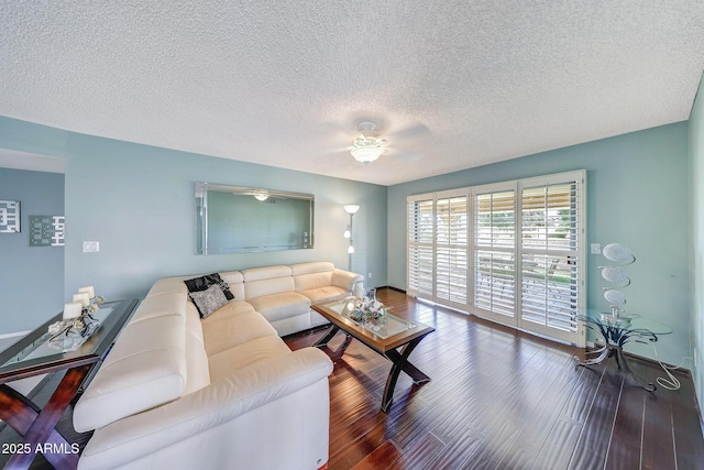 living room featuring a ceiling fan, a textured ceiling, and wood finished floors