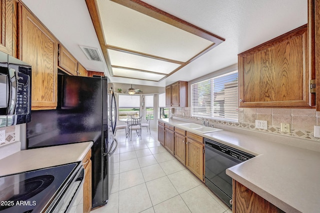 kitchen with visible vents, dishwashing machine, light countertops, a sink, and light tile patterned floors