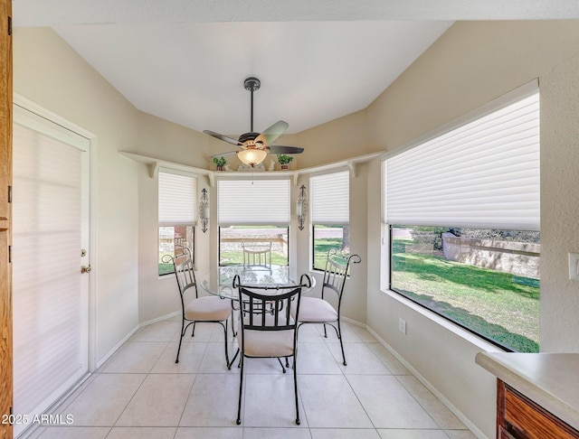dining room with a ceiling fan, baseboards, light tile patterned floors, and lofted ceiling