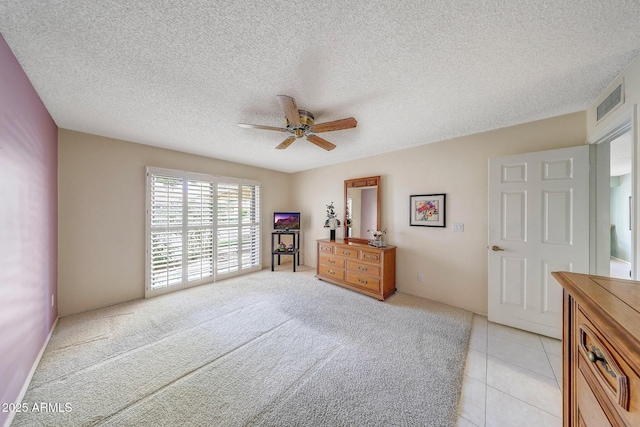 bedroom featuring a textured ceiling, access to exterior, a ceiling fan, light tile patterned floors, and visible vents