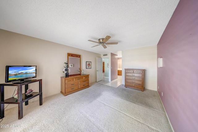 carpeted bedroom featuring ceiling fan, a textured ceiling, and visible vents