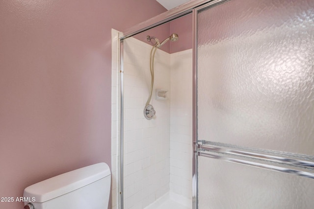 full bath featuring a stall shower and toilet