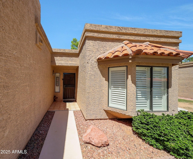 view of exterior entry with stucco siding