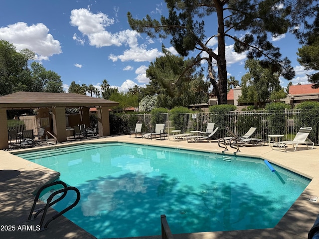 pool with a gazebo, fence, and a patio