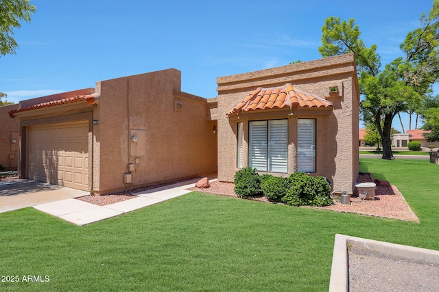 view of front of home featuring a tiled roof, a front yard, a garage, concrete driveway, and stucco siding