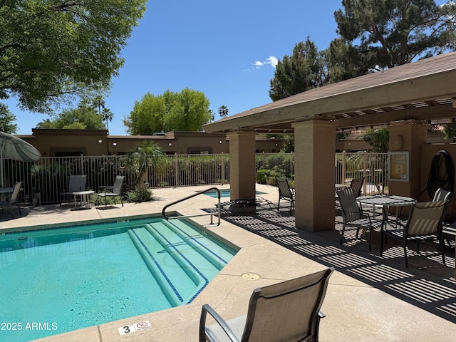 community pool featuring fence and a patio area