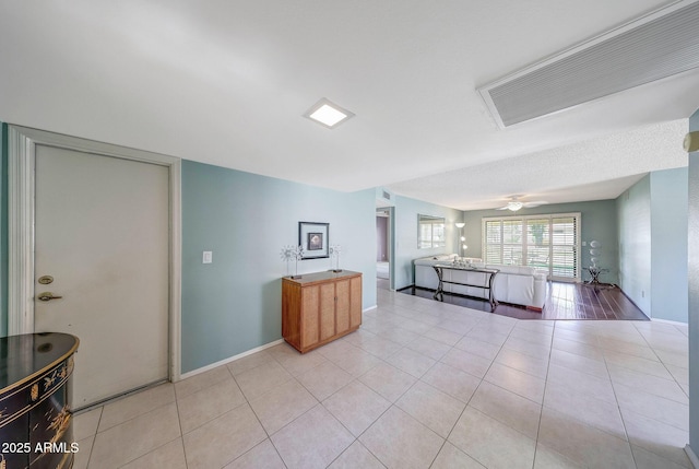 living room with light tile patterned floors, baseboards, and visible vents