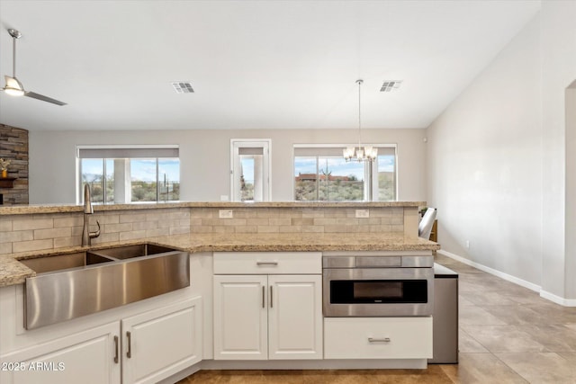27420 N 170th St, Rio Verde, AZ 85263 - kitchen with a sink, visible vents, light stone counters, and vaulted ceiling