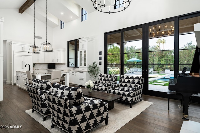 living room featuring a notable chandelier, high vaulted ceiling, dark wood finished floors, and beam ceiling