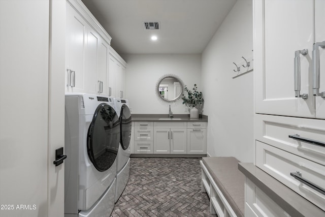 clothes washing area with visible vents, recessed lighting, separate washer and dryer, a sink, and cabinet space