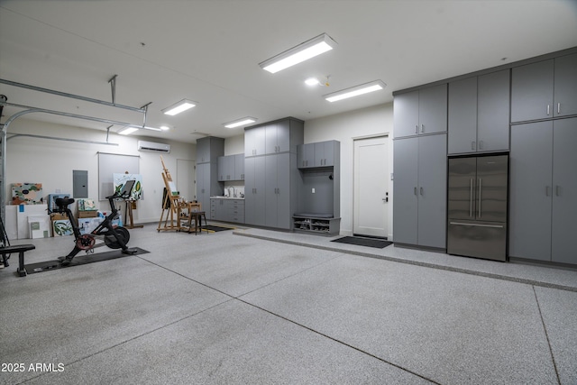 garage featuring built in refrigerator, a wall unit AC, and electric panel